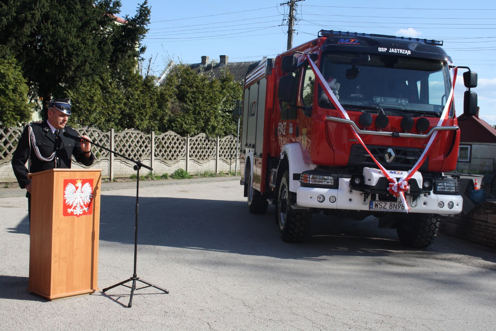 Burmistrz Jastrzębia - Andrzej Bracha przy mównicy, po prawej nowym wóz strażacki dla OSP Jastrząb